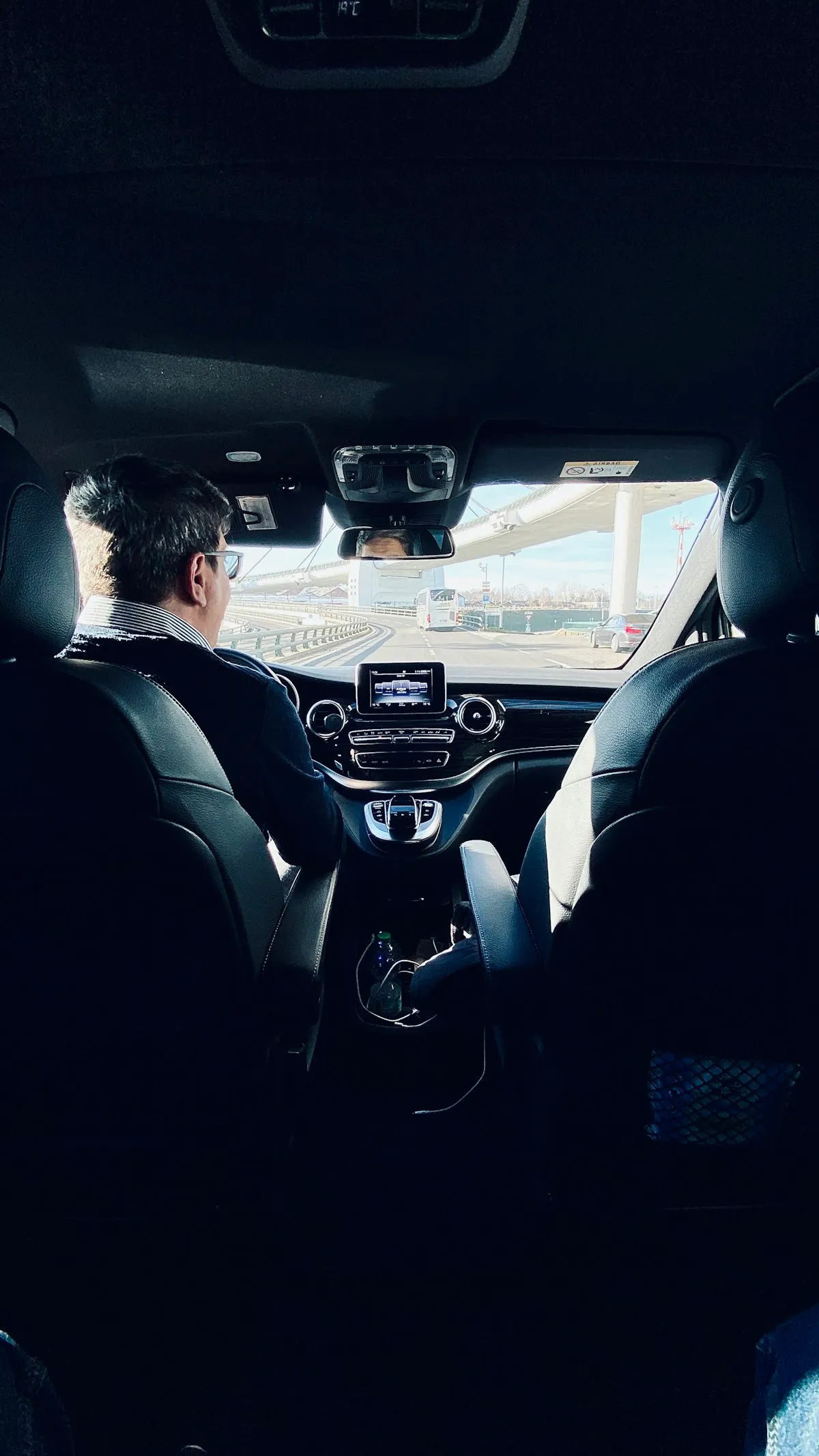Chauffeur vu de dos au volant d'une berline